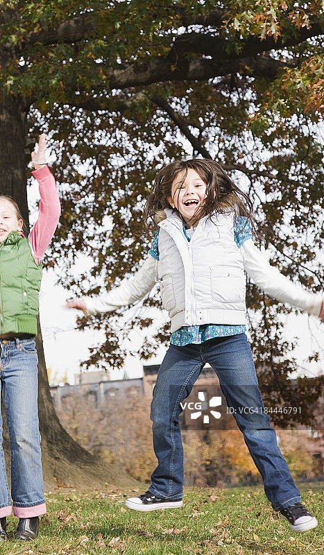 在公园里跳跃的两个女孩图片素材