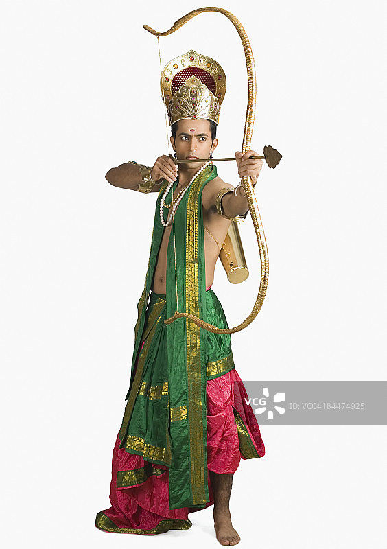 扮演阿朱那角色并拿着弓箭的年轻男人图片素材