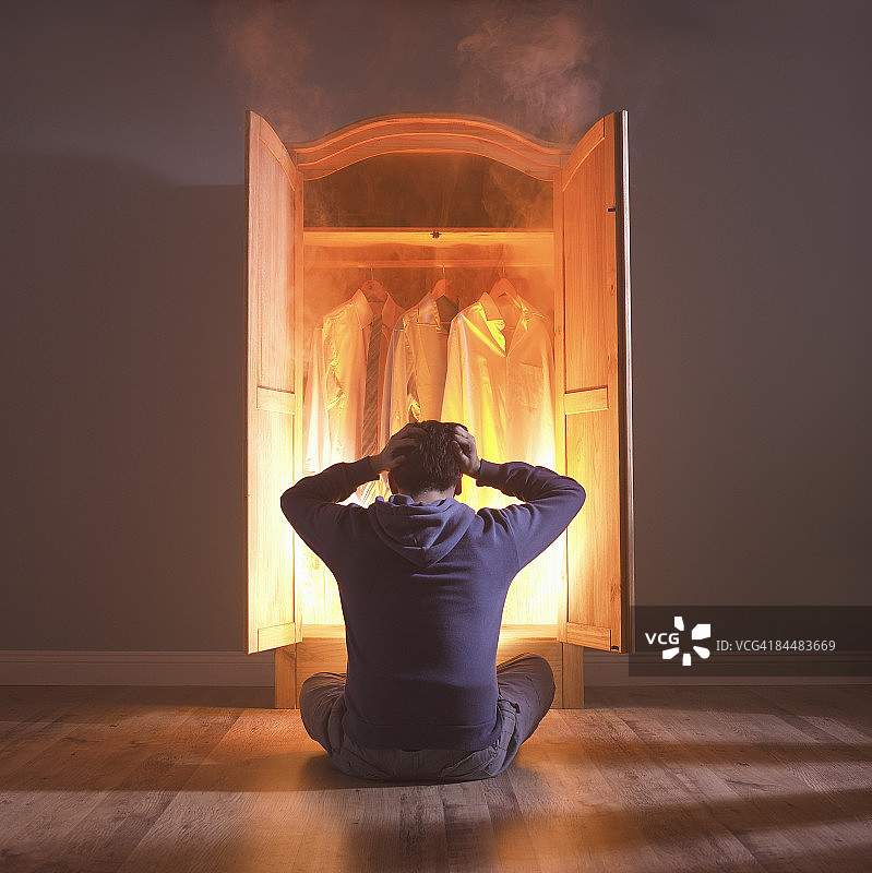 年轻人坐在燃烧的衣服前图片素材