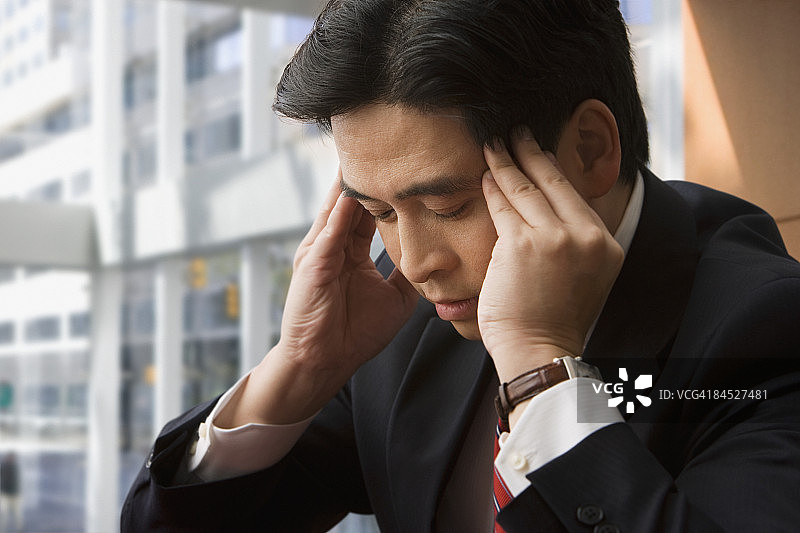 揉着额头的中国商人图片素材