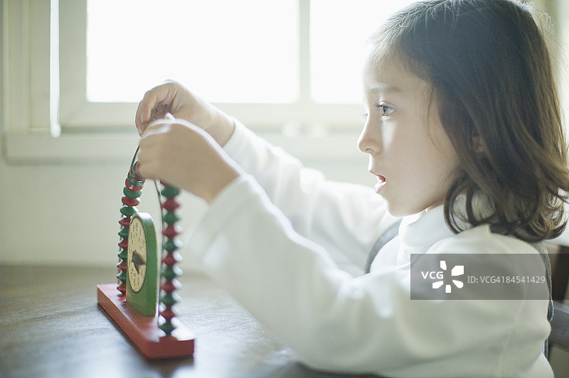 女孩玩玩具侧面视角图片素材