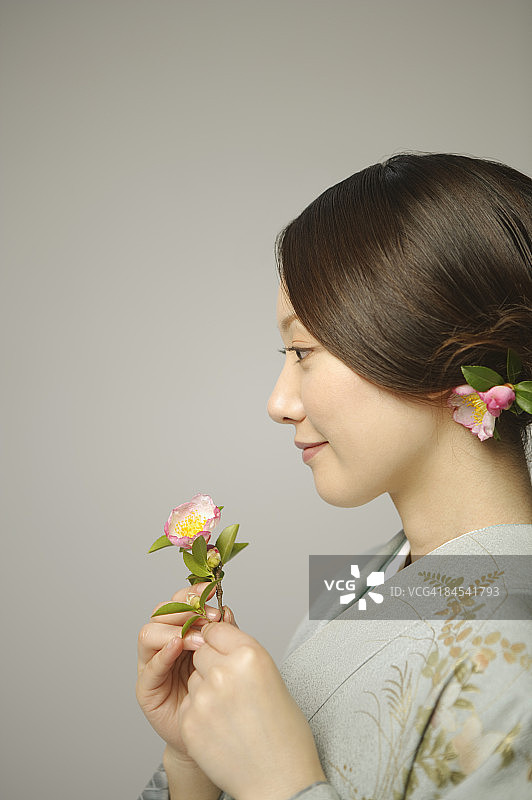 身穿和服手持鲜花的女人，工作室拍摄图片素材