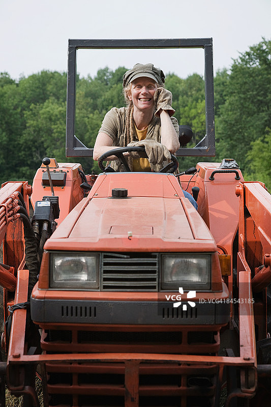 农场工人在有机农场的拖拉机上图片素材