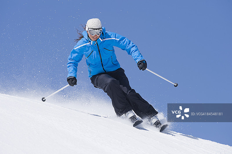 身穿蓝色夹克的女人滑雪图片素材