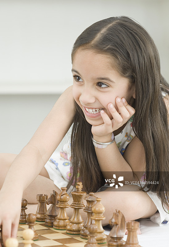 下棋并微笑的女孩特写图片素材