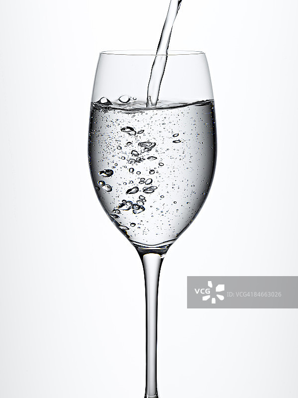 气泡水倒入葡萄酒杯中图片素材