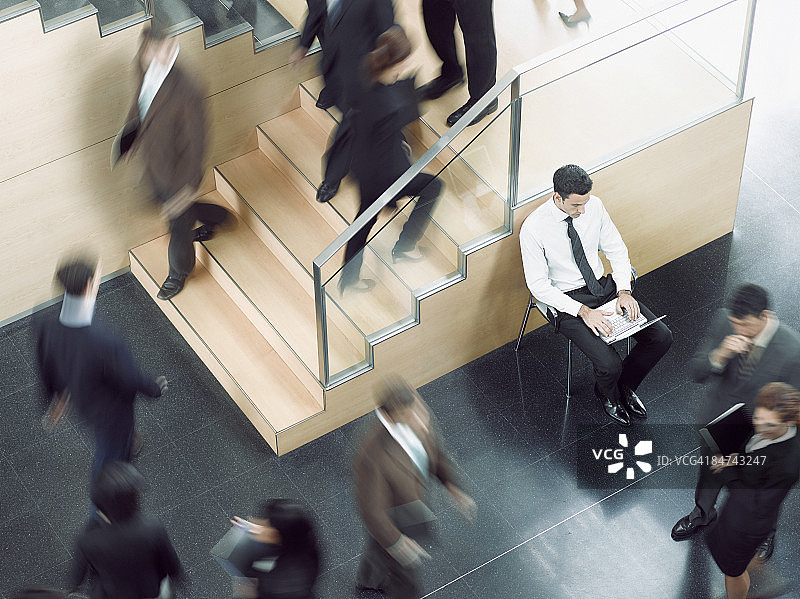 在繁忙办公室走廊工作的商人图片素材