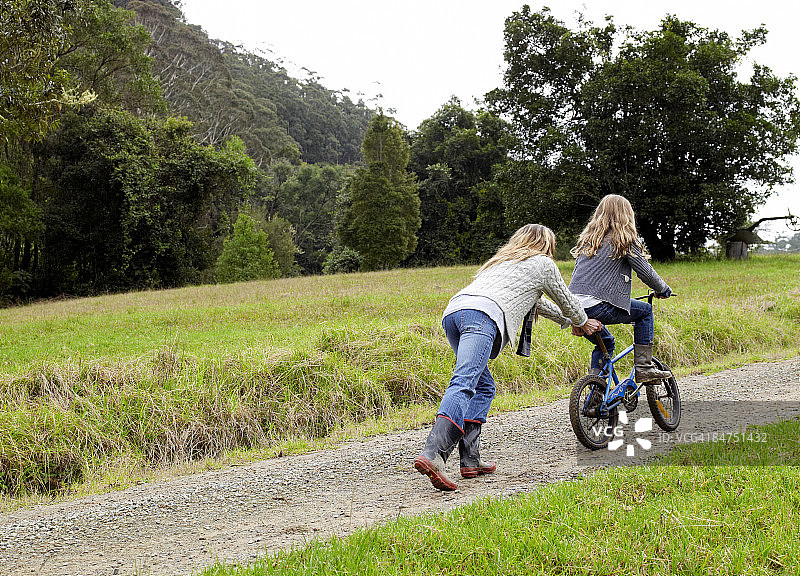 母亲推着女儿上坡图片素材