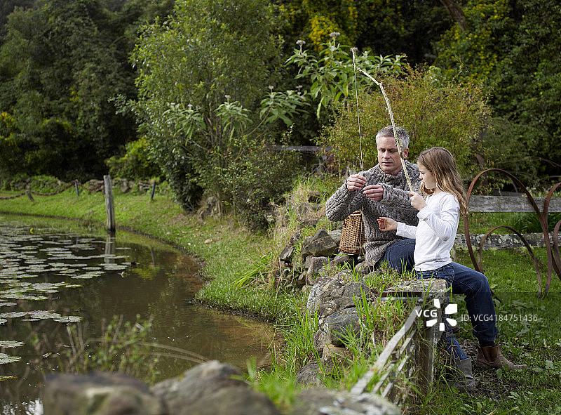 父亲帮助女儿整理鱼线图片素材