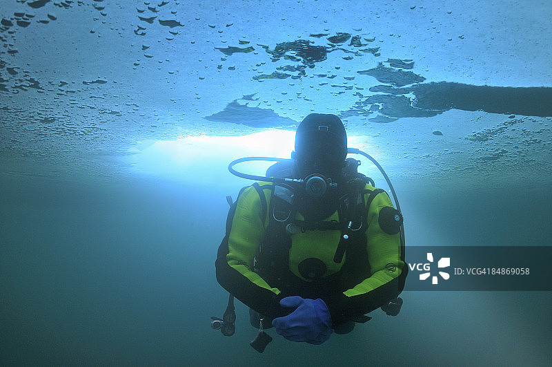 潜水员和穿过冰洞的阳光（水下）图片素材