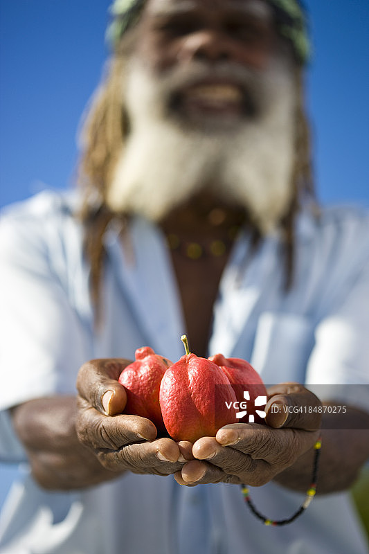 微笑的牙买加男人和西非荔枝果图片素材