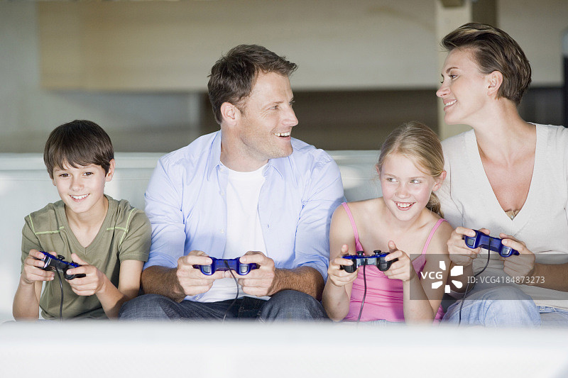 父母和儿子女儿玩电子游戏图片素材