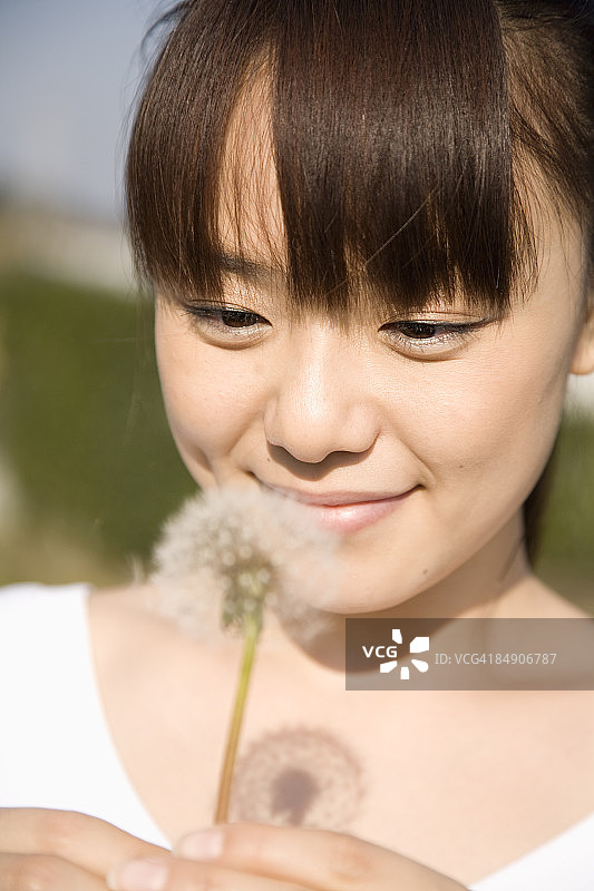 看着蒲公英绒毛的女孩图片素材