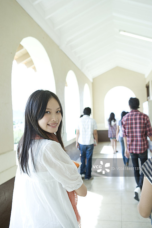 年轻女人在走廊里行走并回头图片素材