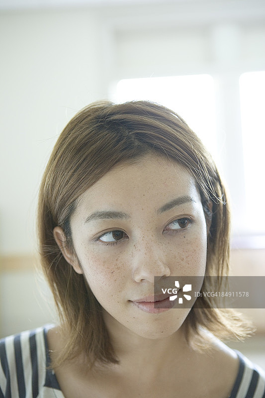 面带微笑，看向远方的年轻女子肖像图片素材