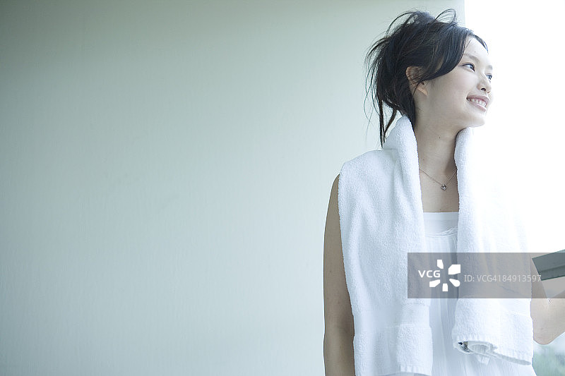 年轻女人面带微笑地看着窗外图片素材