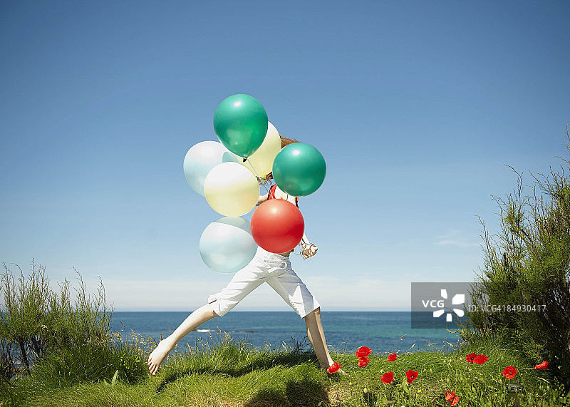 年轻女孩拿着气球奔跑图片素材