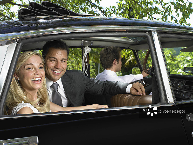 在车里欢笑的婚礼夫妇图片素材