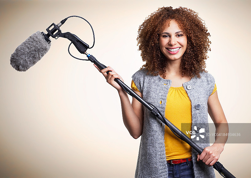 拿着杆式麦克风的年轻女子图片素材
