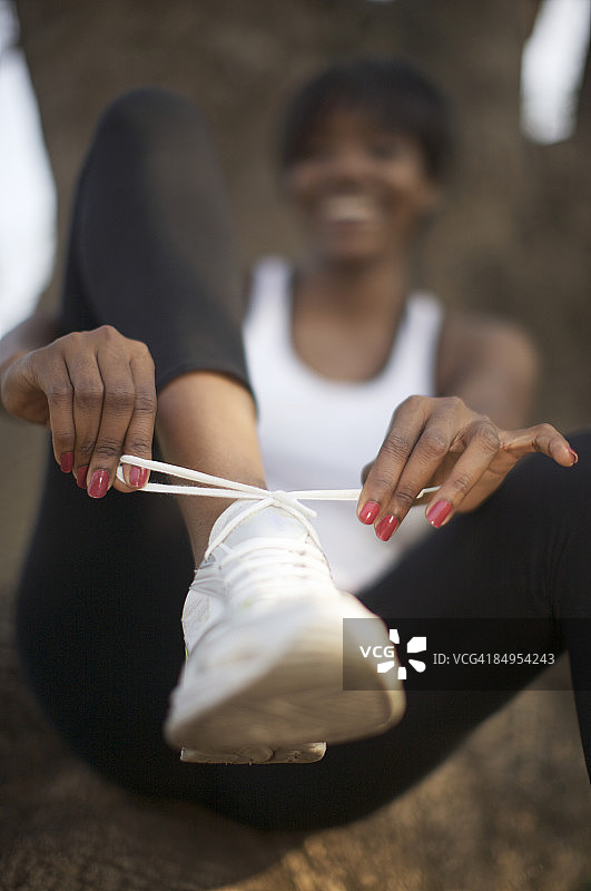 在公园里系鞋带的女人，南非夸祖鲁-纳塔尔省彼得马里茨堡图片素材