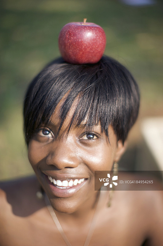 头顶苹果的女人。南非夸祖鲁-纳塔尔省彼得马里茨堡图片素材