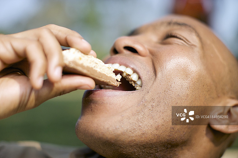男人在南非夸祖鲁-纳塔尔省彼得马里茨堡吃健康棒图片素材