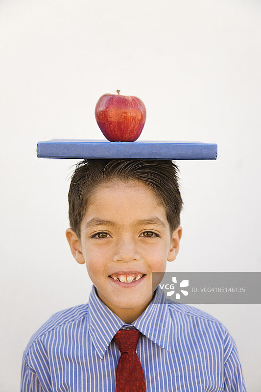 头顶书本和苹果的少年图片素材