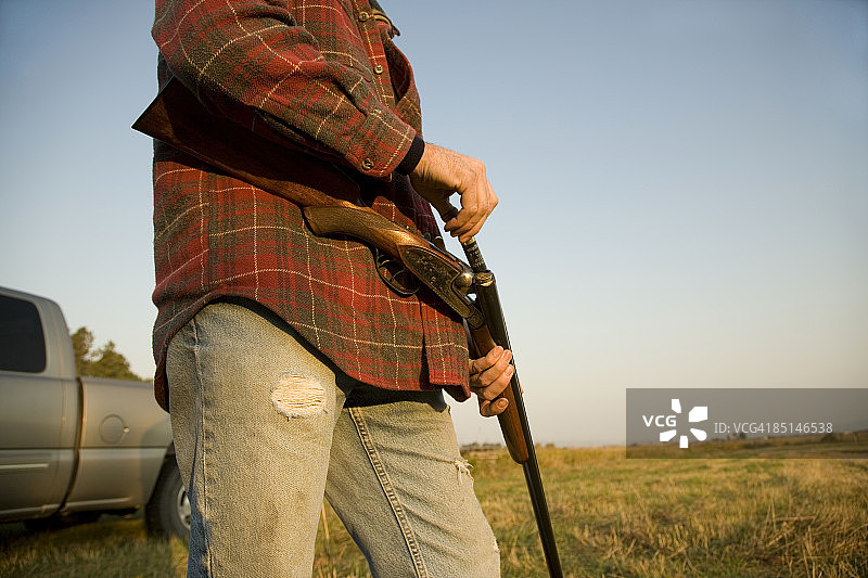 男子在卡车旁装填猎枪的主观视角图片素材