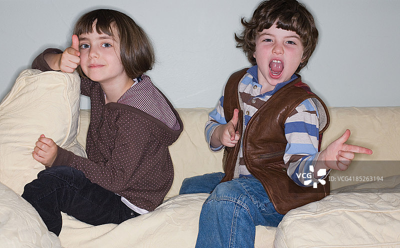 男孩和女孩在沙发上玩牛仔游戏图片素材