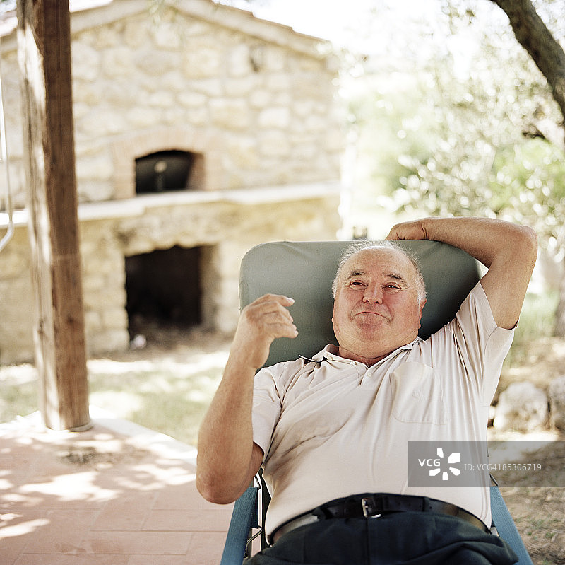 坐在花园椅上的中年男人图片素材