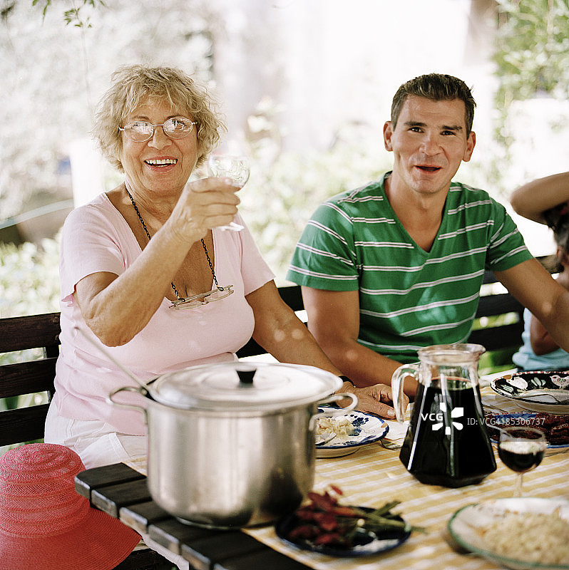 中年妇女在花园晚餐上敬酒图片素材
