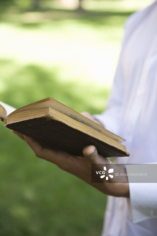 男子手持祈祷书的局部图片素材