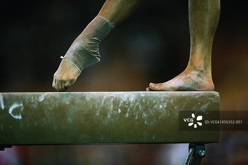 体操，女子在平衡木上保持平衡，特写图片素材