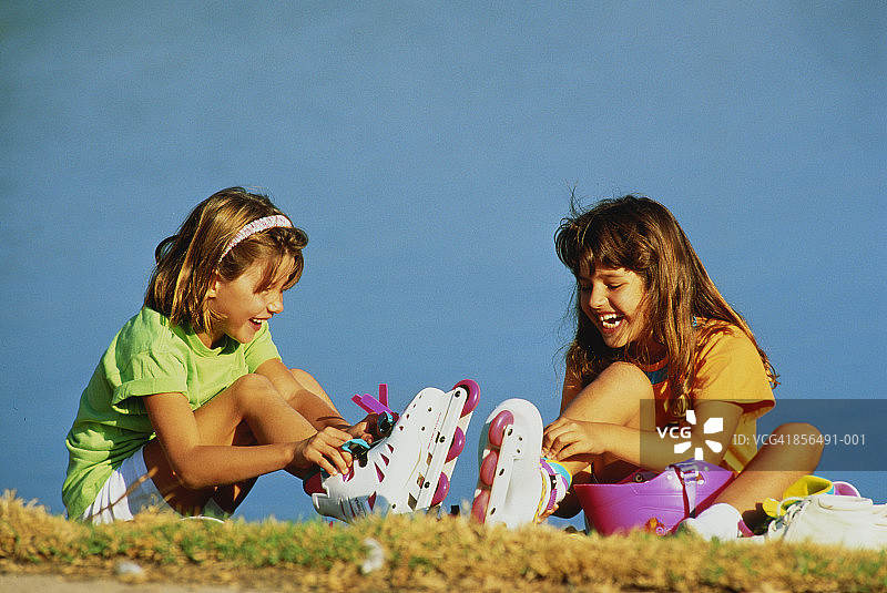 坐在草地上穿旱冰鞋的女孩（8-10岁）图片素材