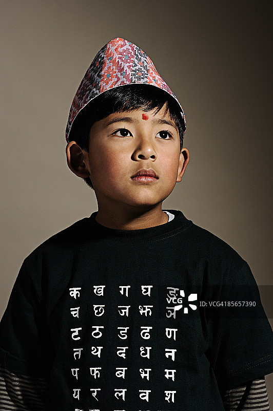 戴着 Dhaka Topee 的年轻尼泊尔男孩图片素材