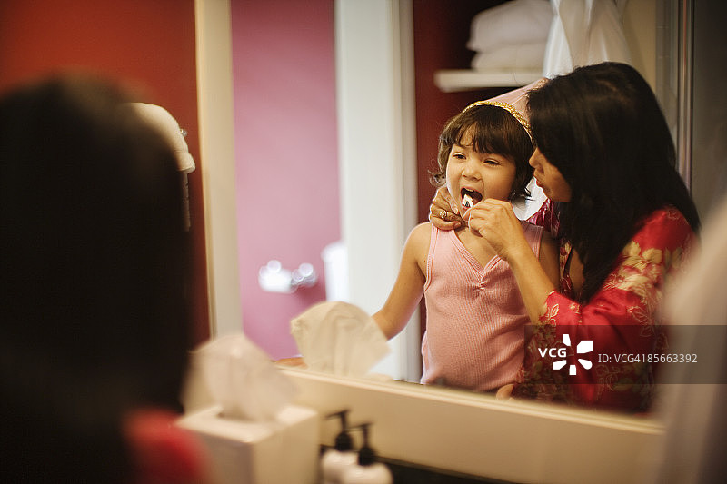 母亲帮助女儿刷牙图片素材