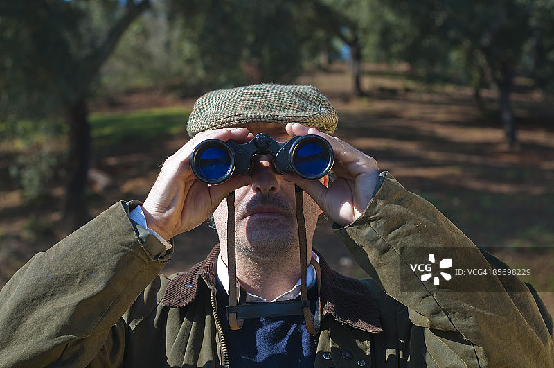 男人用双筒望远镜观察图片素材
