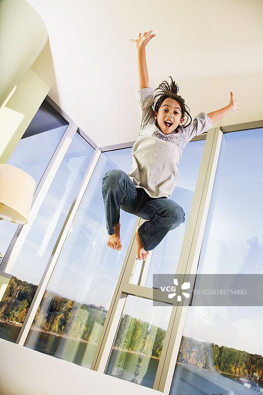 在沙发床上跳跃的少女图片素材