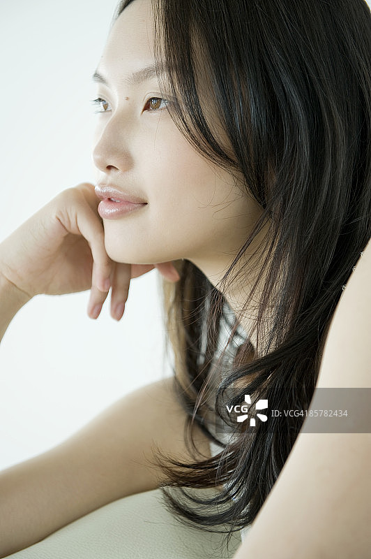 手托下巴、看向远方的日本女子图片素材