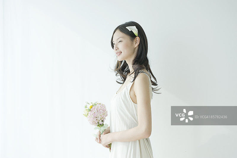 手捧鲜花的日本女人侧面照图片素材