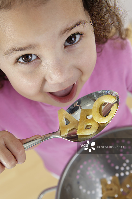 女孩吃字母意大利面图片素材