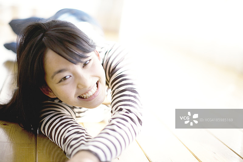 躺在地板上微笑的日本女人肖像图片素材