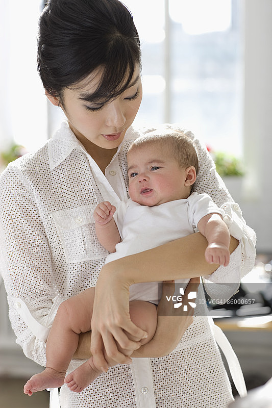年轻的亚洲女人抱着婴儿图片素材