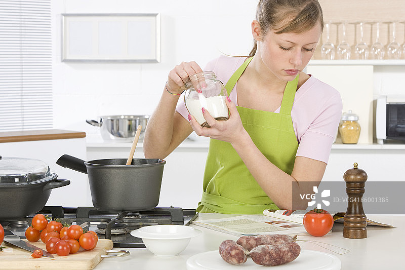 女人在厨房阅读食谱做饭图片素材