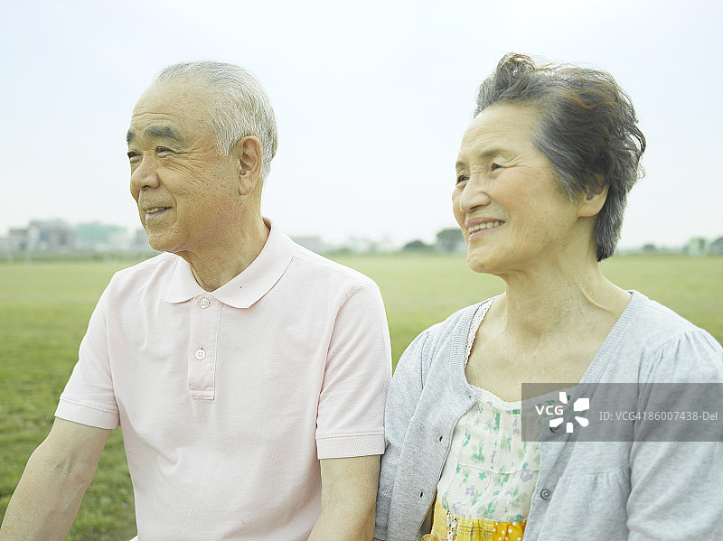 年长夫妇坐着看向远方，面带微笑图片素材