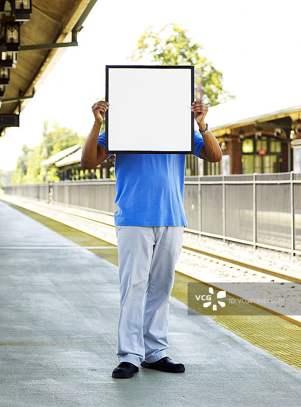 在城镇，脸部被标牌遮住的男人图片素材