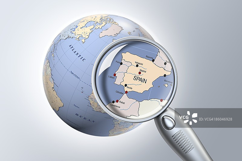 放大镜显示地球仪上的西班牙特写图片素材