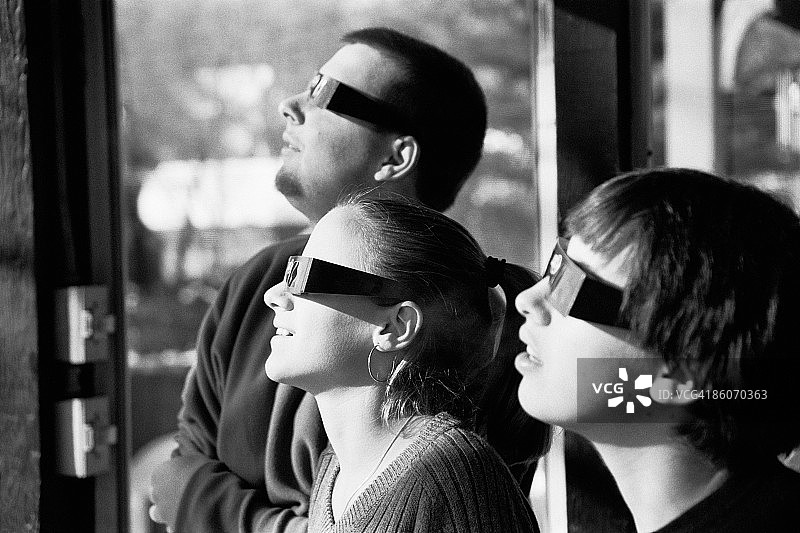 人们戴着太阳镜观看日食图片素材