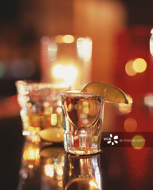 酒吧台上的龙舌兰酒，配有盐、青柠和蜡烛图片素材