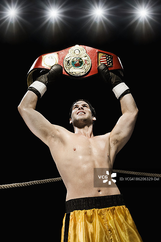 拳击手在拳击台上举起冠军腰带图片素材